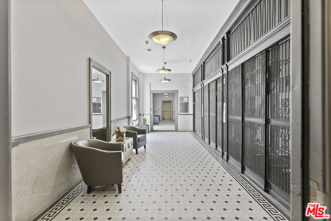 108 West 2nd Street, Unit 708 Los Angeles, CA 90012 - Photo 31 of 40 a living room with furniture a chandelier and a rug
