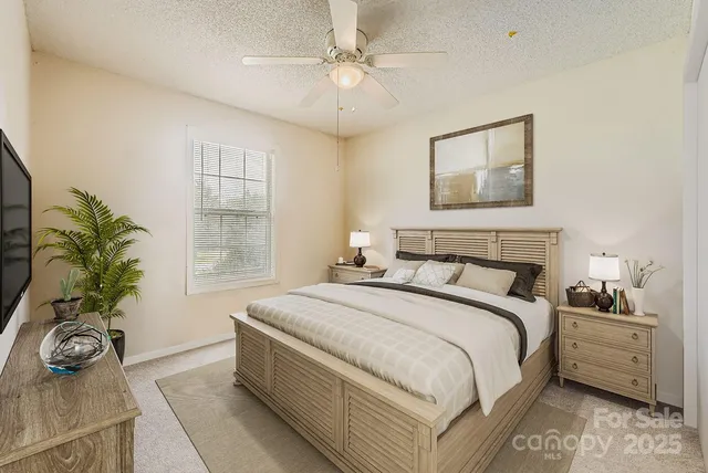 a bedroom with a bed and a potted plant