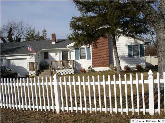 104 Pinewood Road Toms River, NJ 08753 - Photo 1 of 3 a front view of white house with a small yard