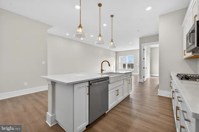 a kitchen with white cabinets appliances and sink
