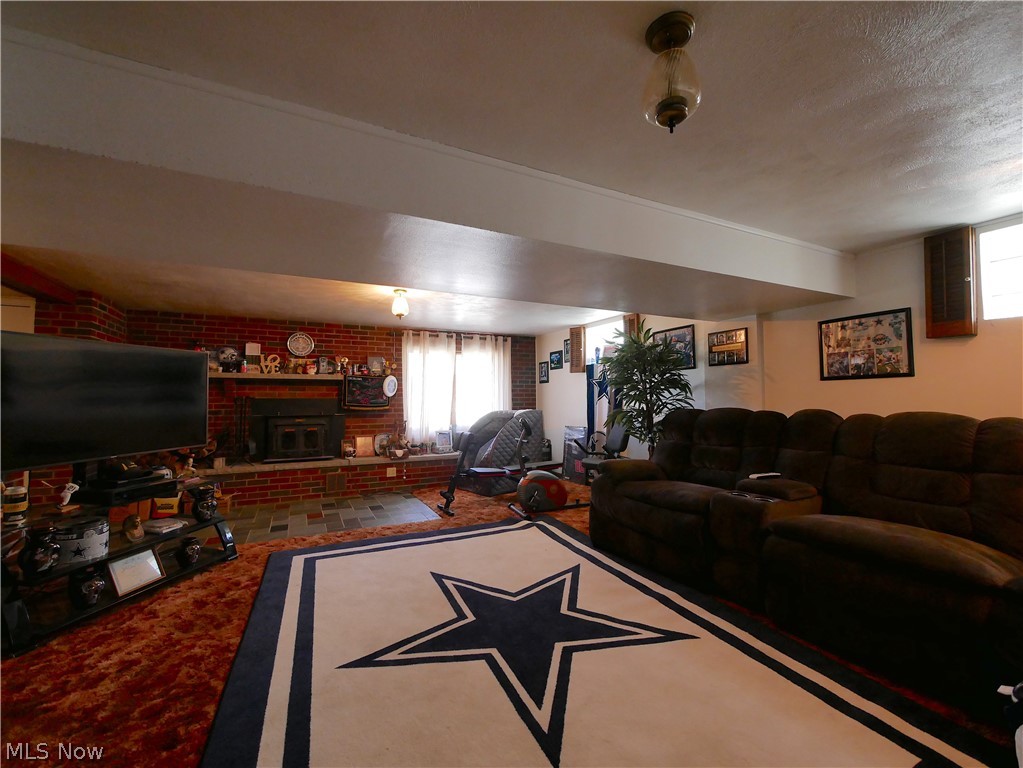 173 Patterson Road Weirton, WV 26062 - Photo 23 of 31 Game room with carpet, brick wall, a brick fireplace, and a textured ceiling