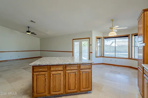 a living room with stainless steel appliances granite countertop furniture a wooden floor and a large window