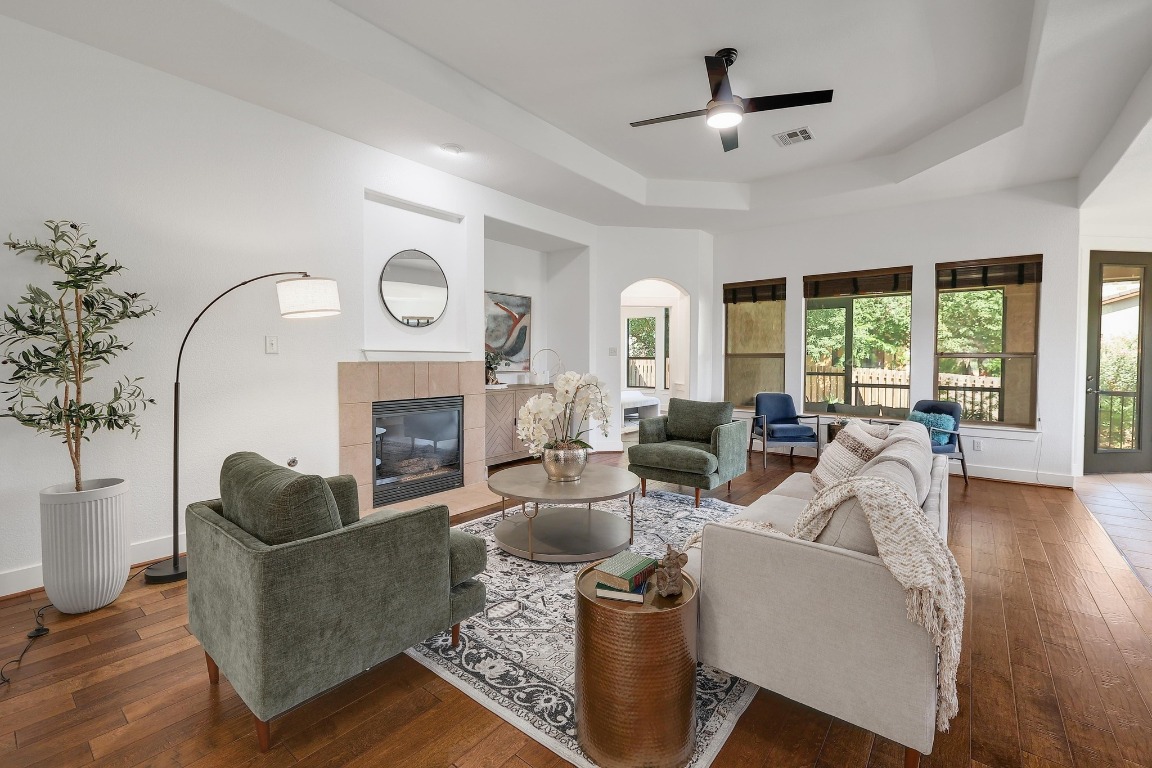 a living room with furniture a fireplace and a large window