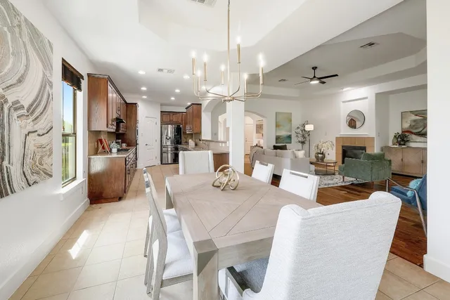 a dining room with granite countertop lots of white furniture and a chandelier