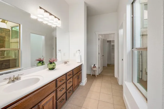 a en suite bathroom with a double vanity sink a mirror and a bathtub