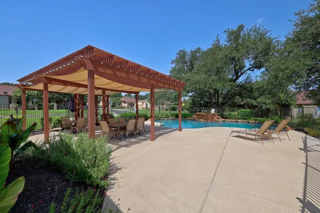 a view of a patio with a table and chairs under an umbrella