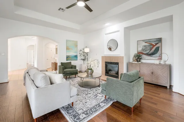 a living room with furniture a fireplace and wooden floor