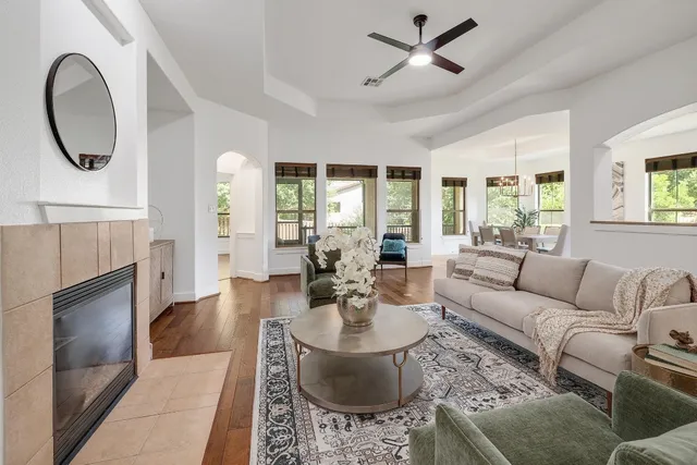 a living room with furniture a fireplace and a chandelier