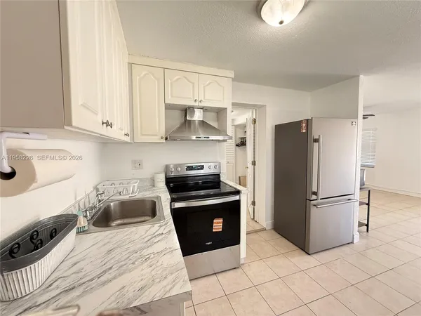 a kitchen with granite countertop a refrigerator and a stove