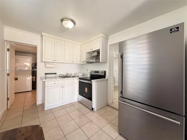 a kitchen with a refrigerator sink and cabinets