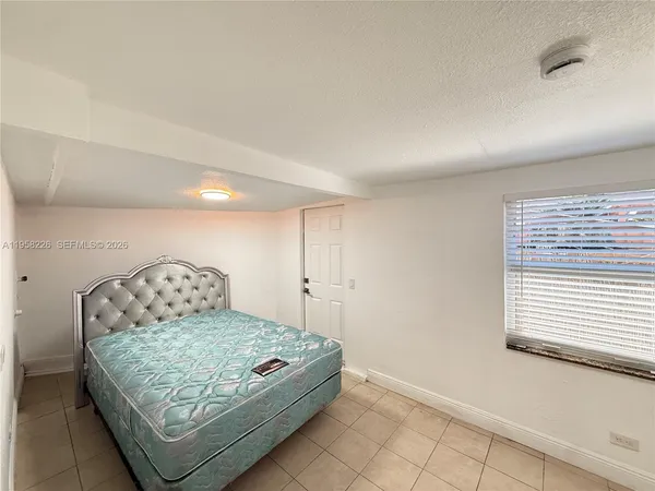 a bedroom with a bed and window