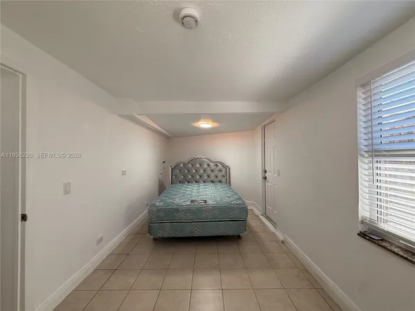a view of a hallway to bedroom with window