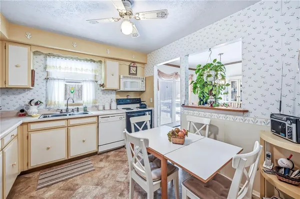 a kitchen with a stove a sink a kitchen island with chairs and wooden floor