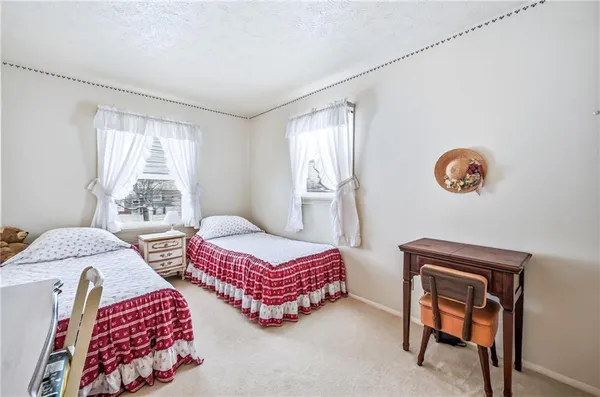 a bedroom with two beds and painting on the wall