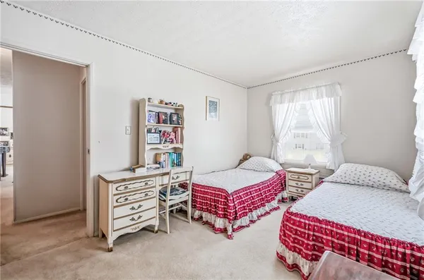 a bedroom with two beds and book shelf
