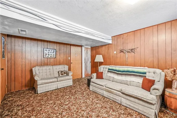 a living room with furniture and a painting on the wall