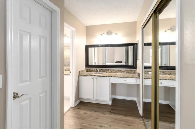 a bathroom with a granite countertop sink and a mirror