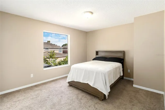 a bed sitting in a bedroom next to a window