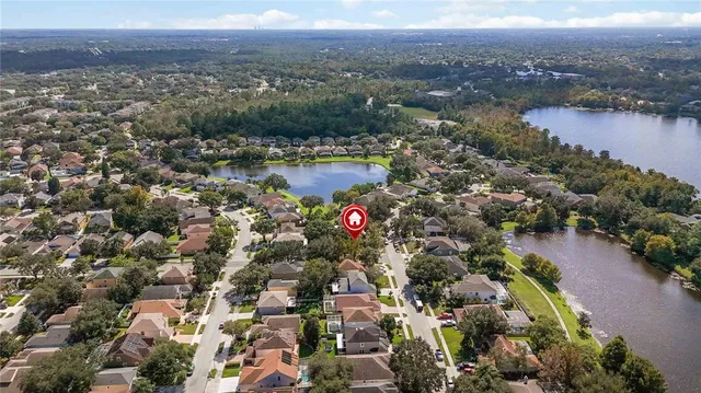 an aerial view of residential houses with outdoor space and lake view