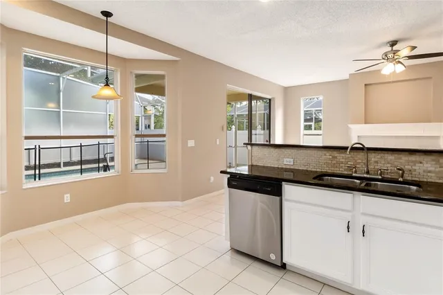 a kitchen with granite countertop a sink and white cabinets