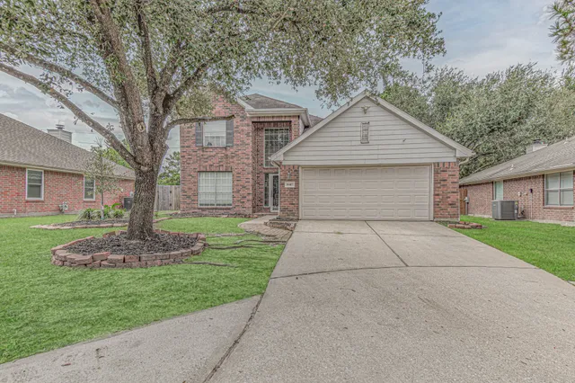 a front view of a house with a yard and trees