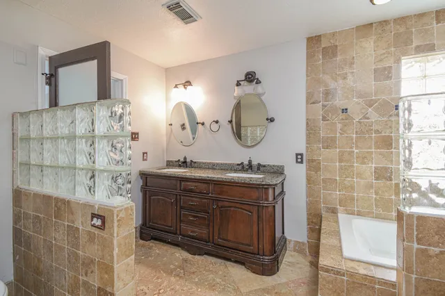 a bathroom with a granite countertop sink a toilet and shower