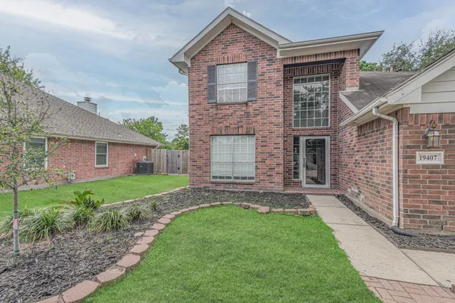 a front view of a house with a garden and yard