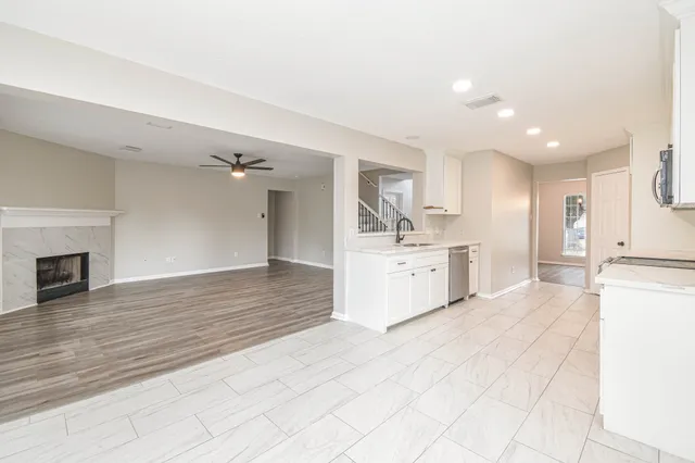 a large white kitchen with kitchen island a sink stainless steel appliances and cabinets