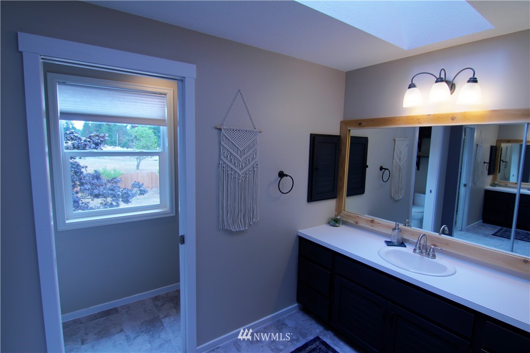 19002 Nutmeg Street Southwest Rochester, WA 98579 - Photo 9 of 19 a bathroom with a double vanity sink a mirror and a shower