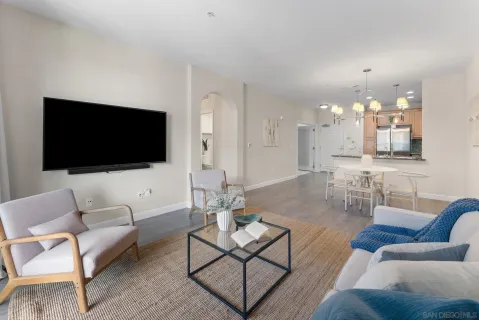 a living room with furniture a flat screen tv and kitchen view