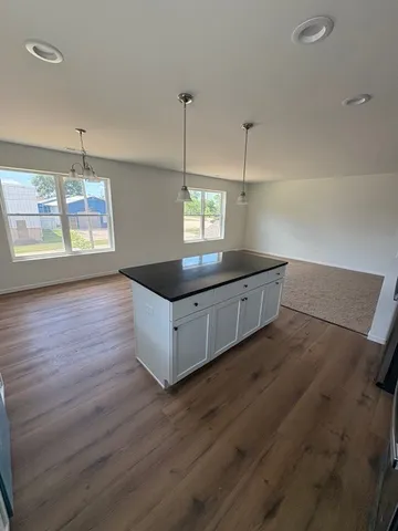 a kitchen with stainless steel appliances granite countertop a sink a window and wooden floor