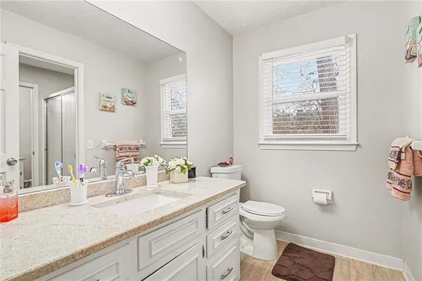 a bathroom with a granite countertop sink and a large mirror