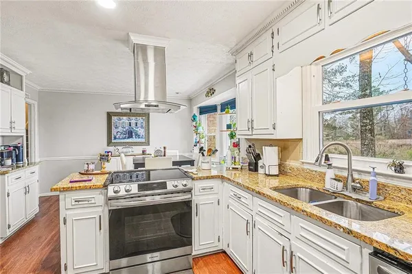 a kitchen with kitchen island white cabinets and stainless steel appliances