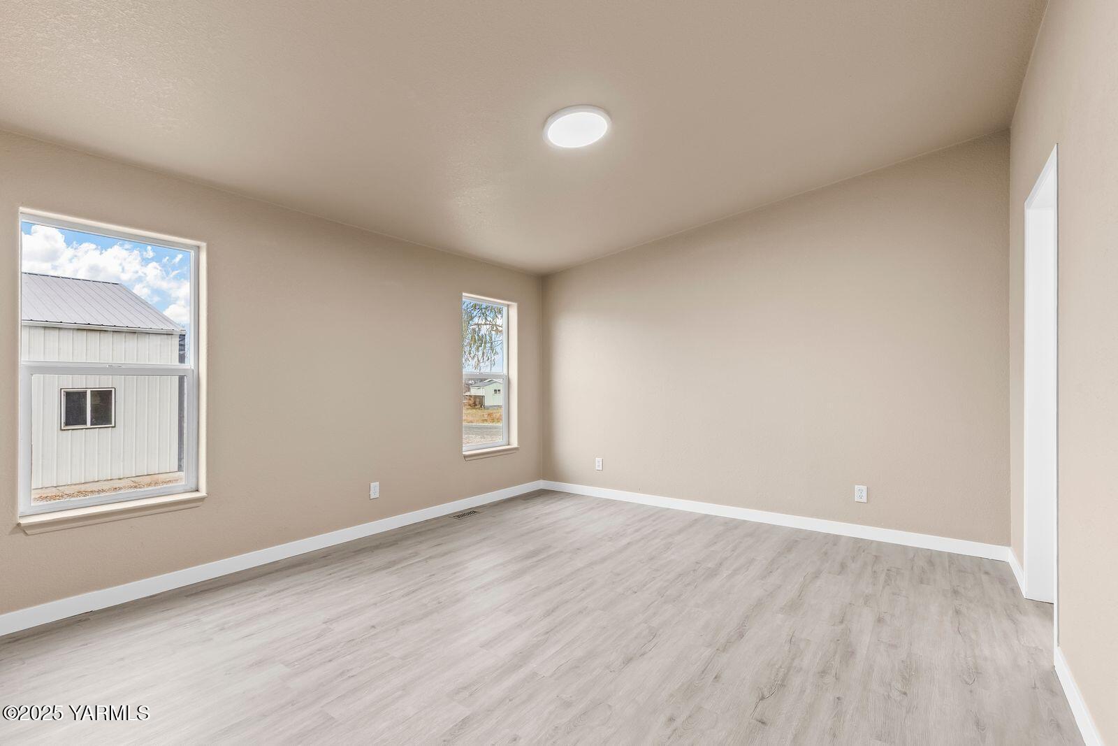 1023 Gibson Road Selah, WA 98942 - Photo 12 of 39 a view of an empty room with wooden floor and a window