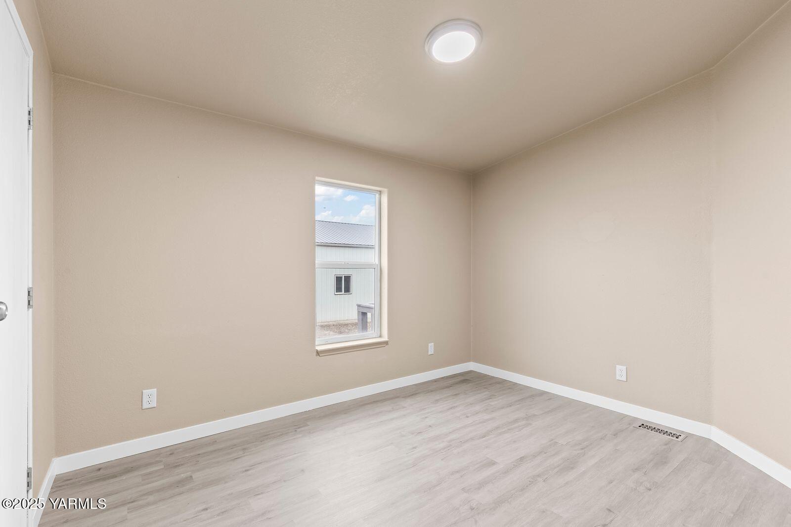 1023 Gibson Road Selah, WA 98942 - Photo 19 of 39 an empty room with wooden floor and windows