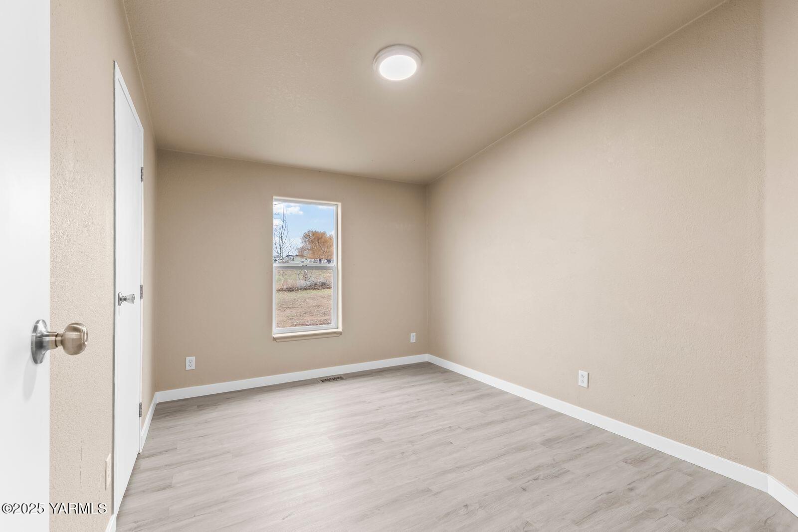 1023 Gibson Road Selah, WA 98942 - Photo 21 of 39 an empty room with wooden floor and windows