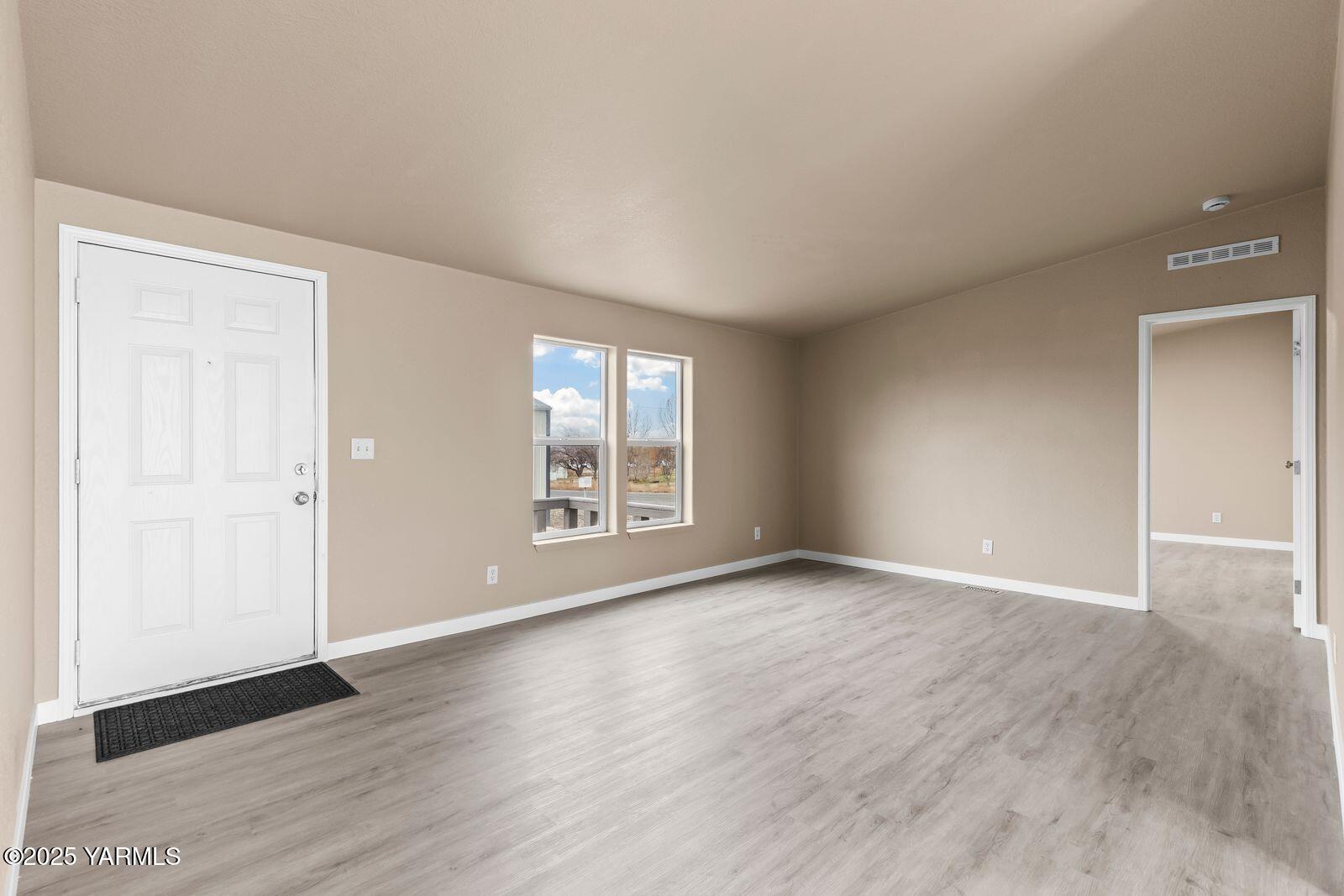 1023 Gibson Road Selah, WA 98942 - Photo 5 of 39 an empty room with wooden floor and windows