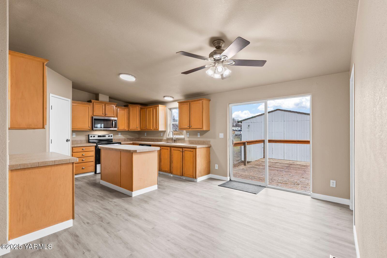 1023 Gibson Road Selah, WA 98942 - Photo 8 of 39 a open kitchen with granite countertop a refrigerator a sink and white cabinets