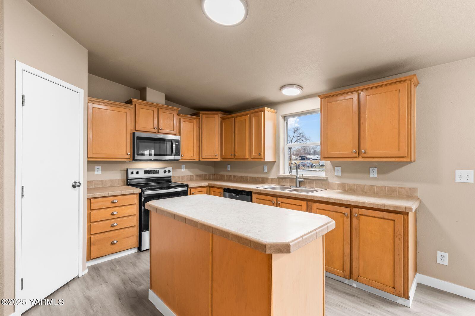 1023 Gibson Road Selah, WA 98942 - Photo 10 of 39 a kitchen with wooden cabinets and white appliances