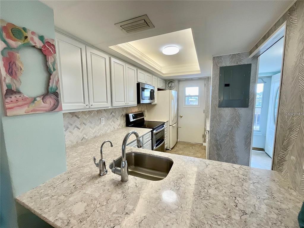 1 Boca Ciega Point Boulevard, Unit 213 St. Petersburg, FL 33708 - Photo 13 of 33 a kitchen with stainless steel appliances granite countertop a sink and a refrigerator