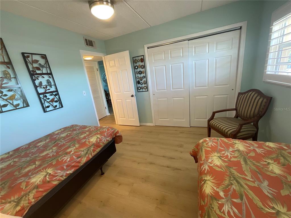 1 Boca Ciega Point Boulevard, Unit 213 St. Petersburg, FL 33708 - Photo 25 of 33 a bedroom with a bed and wooden floor