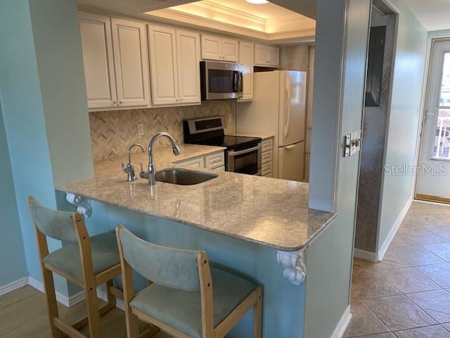 1 Boca Ciega Point Boulevard, Unit 213 St. Petersburg, FL 33708 - Photo 9 of 33 a kitchen with stainless steel appliances granite countertop a sink and a refrigerator