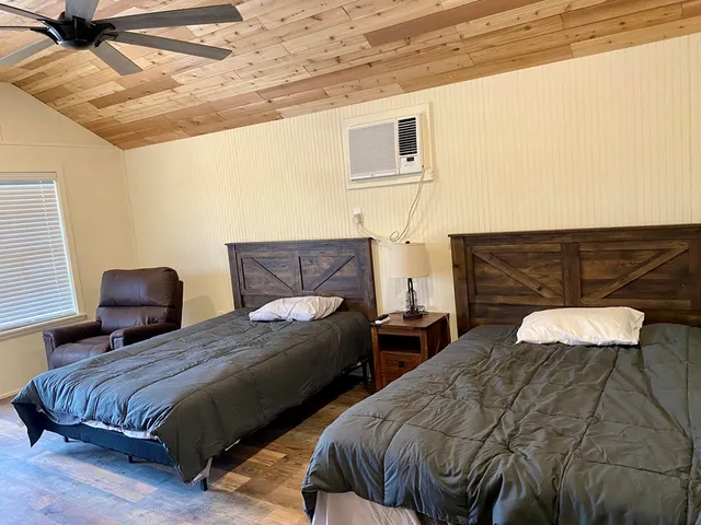 a bedroom with two beds and a night stand