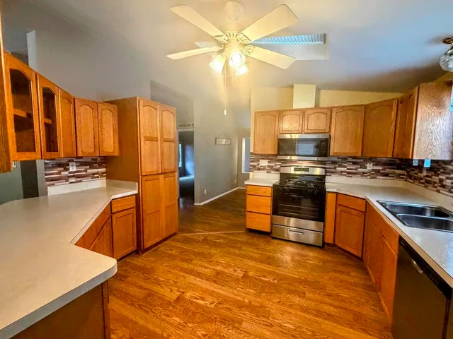 a kitchen with stainless steel appliances granite countertop a stove a sink and a refrigerator