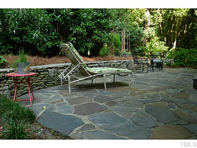3700 Swann Street Raleigh, NC 27612 - Photo 15 of 20 Stone patio with stacked stone wall on the side of the home.