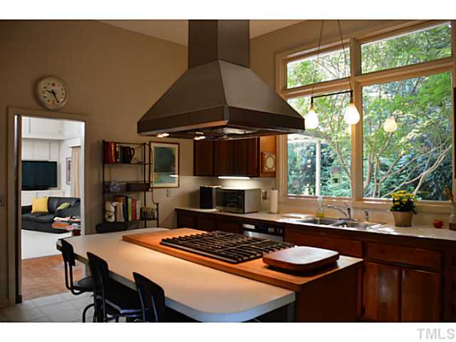 3700 Swann Street Raleigh, NC 27612 - Photo 9 of 20 Chefs kitchen features black walnut cabinets, gas range, stainless appliances, and custom vent hood over the island.