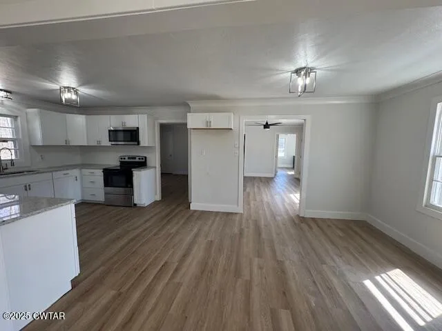 a view of a kitchen with cabinets and wooden floor