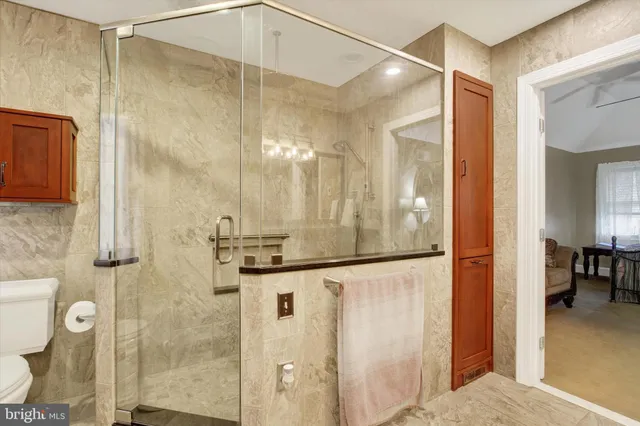 a bathroom with a granite countertop sink a mirror a vanity and a shower