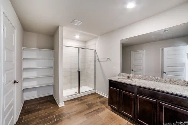 a spacious bathroom with a granite countertop sink and a mirror