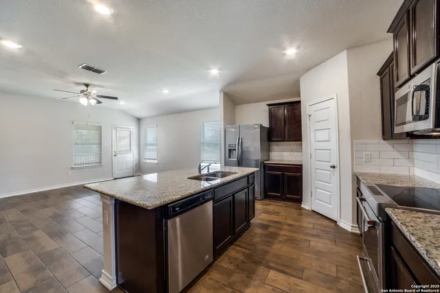 a kitchen with stainless steel appliances granite countertop a sink stove and refrigerator